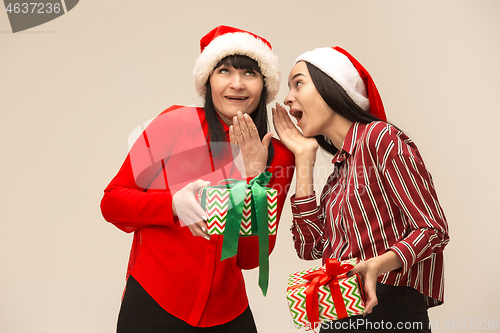 Image of Happy family in Christmas sweater posing on a red background in the studio.