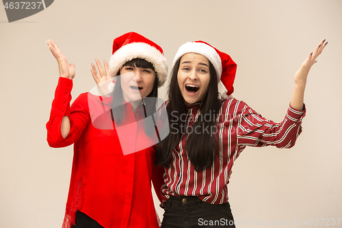 Image of Happy family in Christmas sweater posing on a red background in the studio.