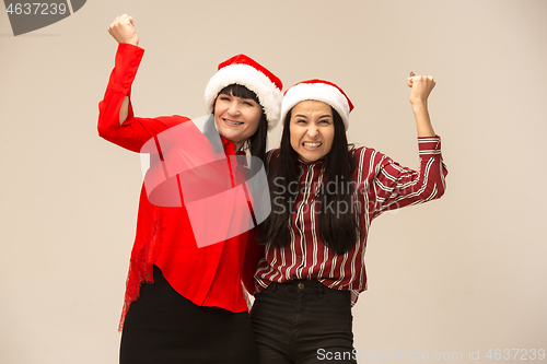 Image of Happy family in Christmas sweater posing on a red background in the studio.