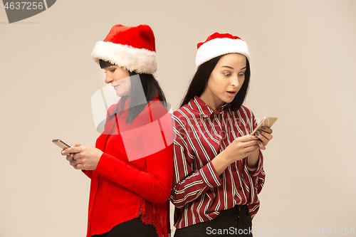 Image of Happy family in Christmas sweater posing on a red background in the studio.