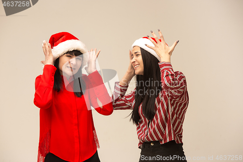 Image of Happy family in Christmas sweater posing on a red background in the studio.