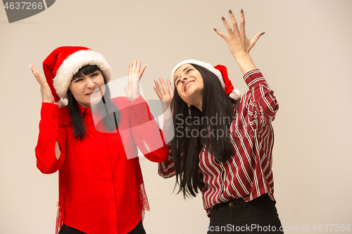 Image of Happy family in Christmas sweater posing on a red background in the studio.