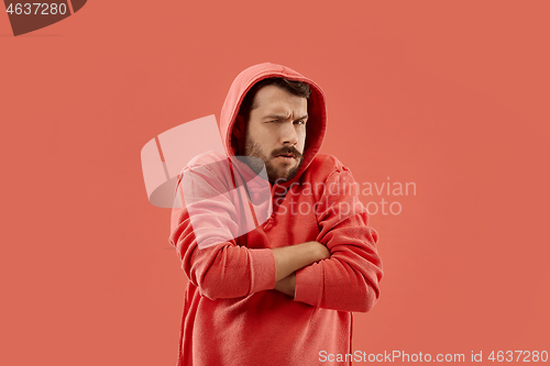 Image of Suspiciont. Doubtful pensive man with thoughtful expression making choice against coral background