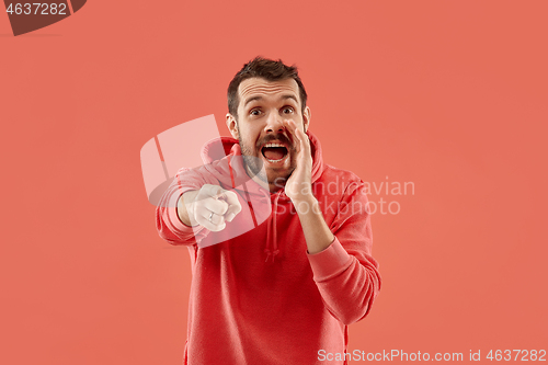 Image of Isolated on coral young casual man shouting at studio