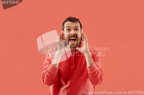 Image of Isolated on coral young casual man shouting at studio