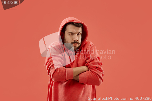 Image of Suspiciont. Doubtful pensive man with thoughtful expression making choice against coral background