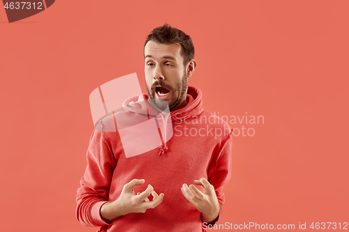 Image of The squint eyed man with weird expression isolated on coral