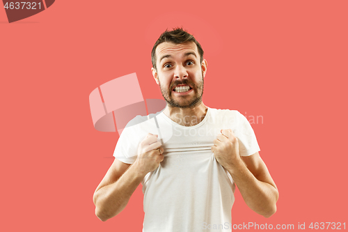 Image of Beautiful man looking suprised and bewildered isolated on coral