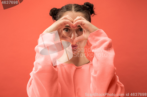 Image of Portrait of attractive cute girl with bright makeup with love isolated over coral background