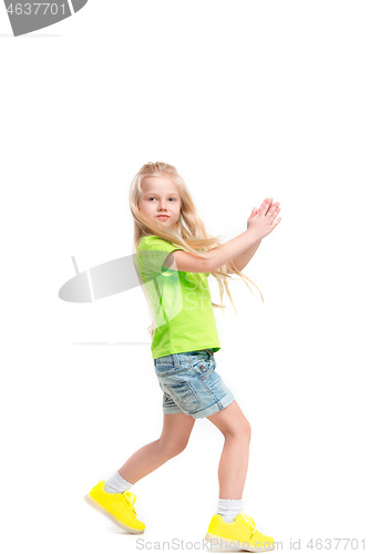 Image of Full length portrait of cute little kid in stylish jeans clothes looking at camera and smiling