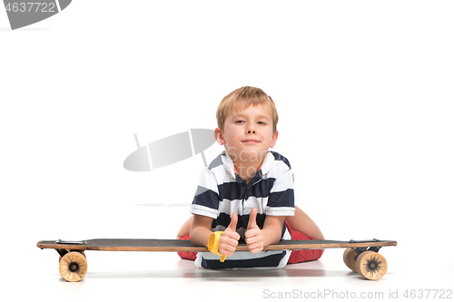 Image of Full length portrait of an adorable young boy riding a skateboard isolated against white background