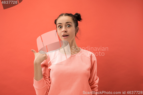 Image of Beautiful woman looking suprised isolated on coral