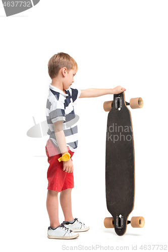Image of Full length portrait of an adorable young boy riding a skateboard isolated against white background