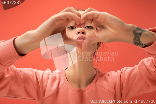 Image of Portrait of attractive cute girl with bright makeup with love isolated over coral background