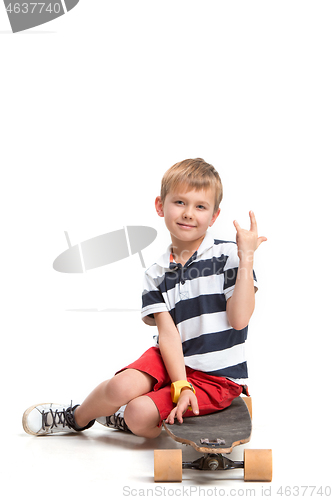 Image of Full length portrait of an adorable young boy riding a skateboard isolated against white background