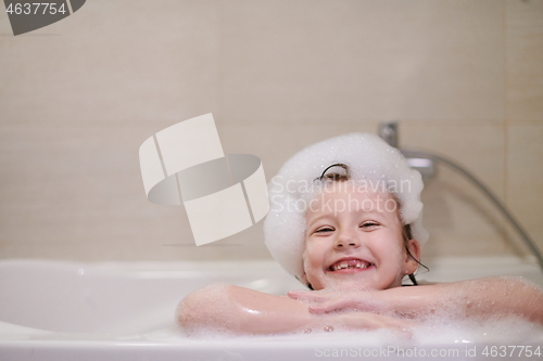 Image of little girl in bath playing with soap foam