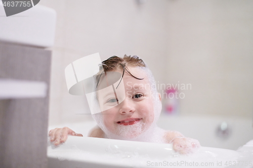 Image of little girl in bath playing with soap foam