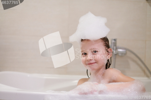 Image of little girl in bath playing with soap foam