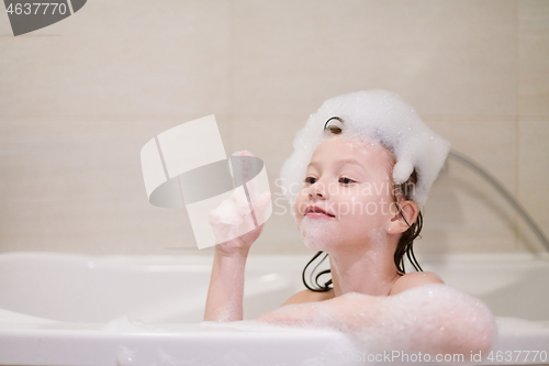 Image of little girl in bath playing with soap foam