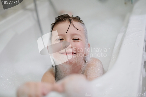 Image of little girl in bath playing with soap foam