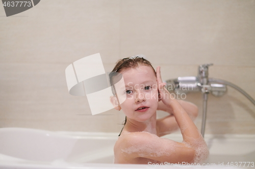 Image of little girl in bath playing with soap foam