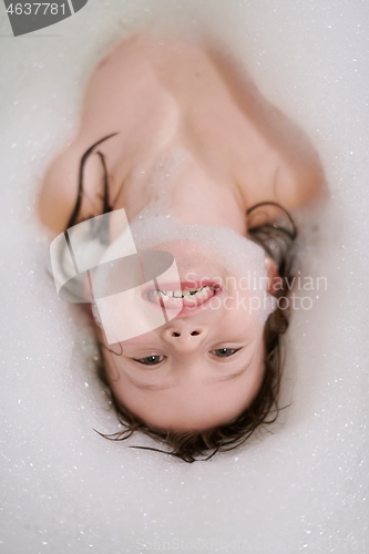 Image of little girl in bath playing with soap foam