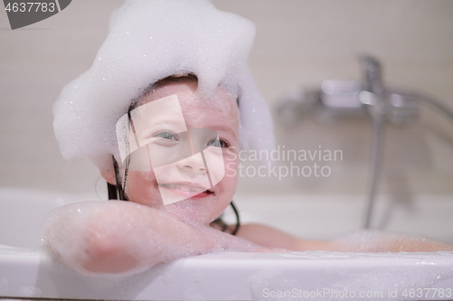 Image of little girl in bath playing with soap foam