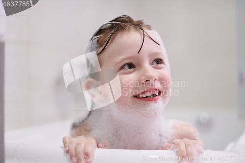 Image of little girl in bath playing with soap foam