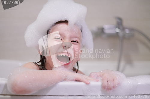 Image of little girl in bath playing with soap foam