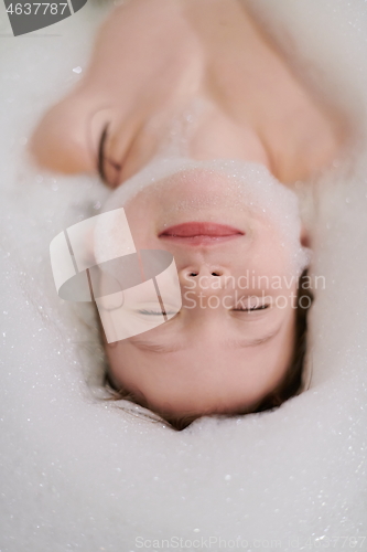 Image of little girl in bath playing with soap foam