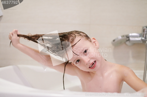 Image of little girl in bath playing with soap foam