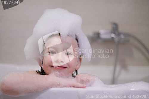 Image of little girl in bath playing with soap foam