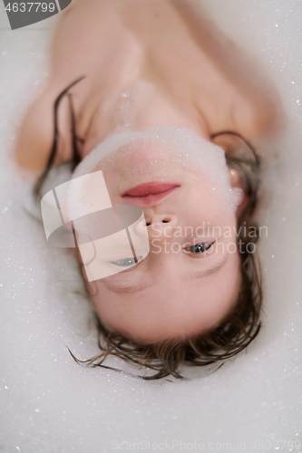 Image of little girl in bath playing with soap foam