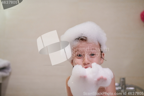 Image of little girl in bath playing with soap foam