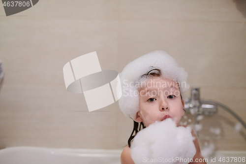 Image of little girl in bath playing with soap foam