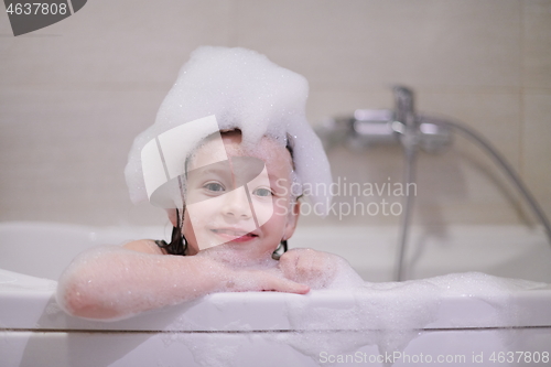 Image of little girl in bath playing with soap foam