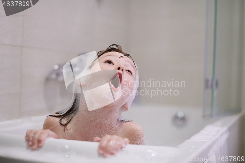 Image of little girl in bath playing with soap foam