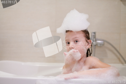 Image of little girl in bath playing with soap foam