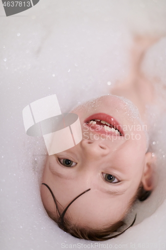 Image of little girl in bath playing with soap foam