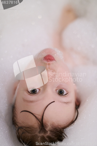 Image of little girl in bath playing with soap foam