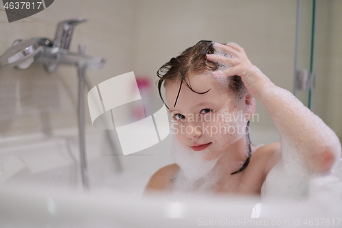 Image of little girl in bath playing with soap foam