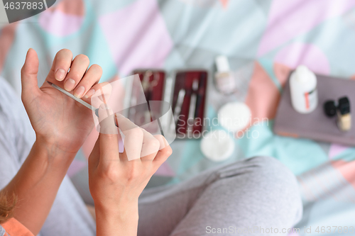 Image of Girl files a fingernail with a nail file