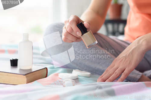 Image of Girl at home in the morning paints nails