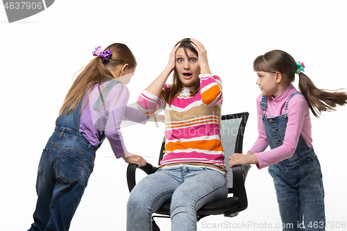 Image of Two daughters unwind mom in an office chair