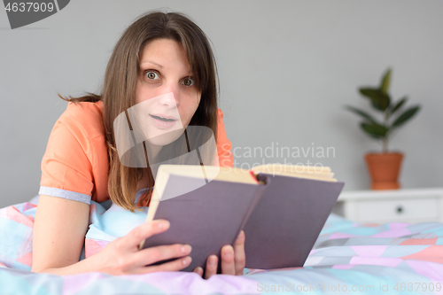 Image of The girl in a slight shock from reading in a book