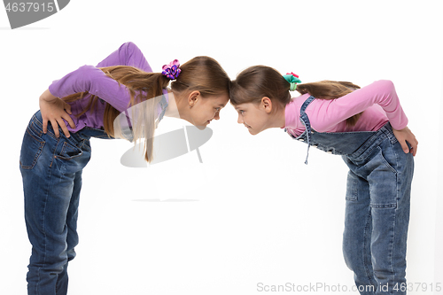Image of quarrel two girls standing leaning their foreheads against to each other