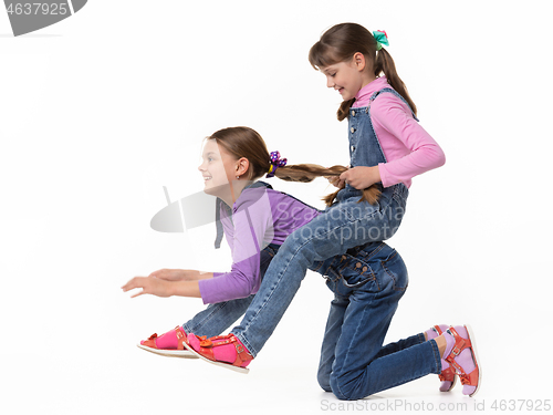 Image of Girl rides another girl on herself on a white background