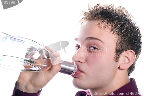 Image of The young man drinks vodka from a bottle. Isolated