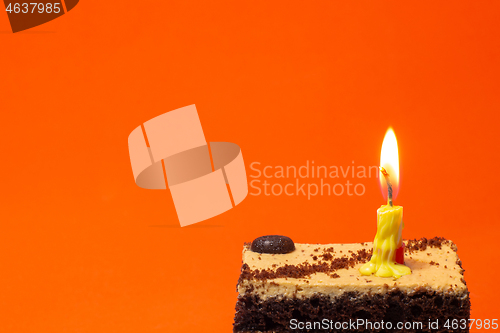 Image of Small candle on a pie on a bright red background