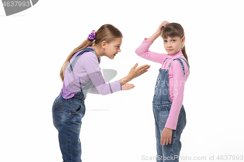 Image of The girl is trying to explain something to her sister, she scratches her head in perplexity